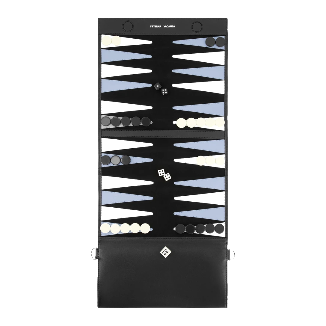 L'Bag Gammon in Nero opened flat as a backgammon board, the cream and black checkers, dice and doubling cube set out on the stitched points