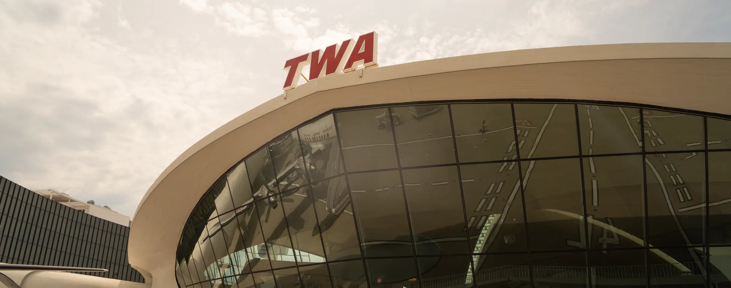 The TWA Flight Center at JFK, its curved concrete roof and glass wall seen from the forecourt